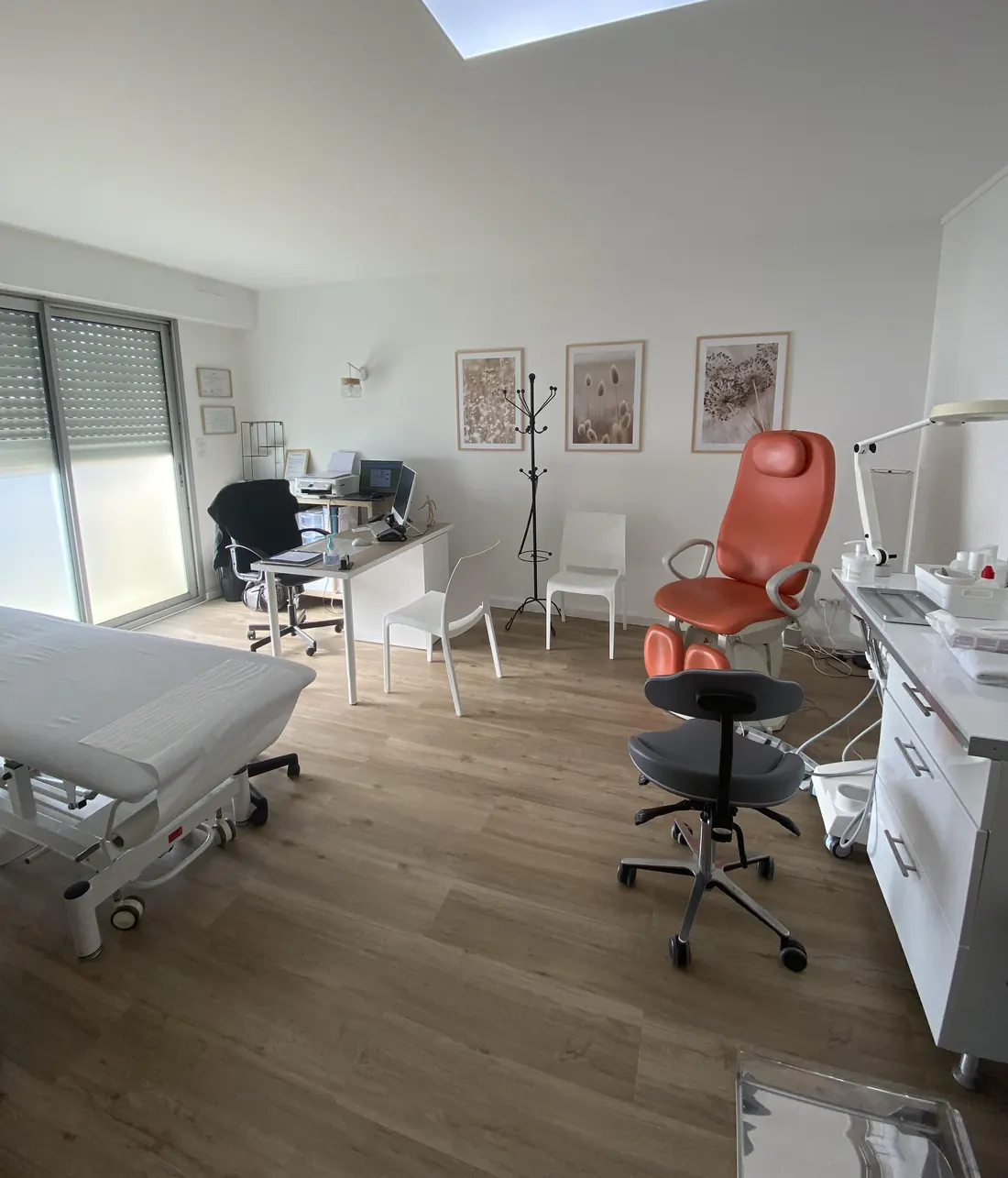 Sa salle de consultation: parquet chêne clair, murs blancs, le fauteuil de podologie orange